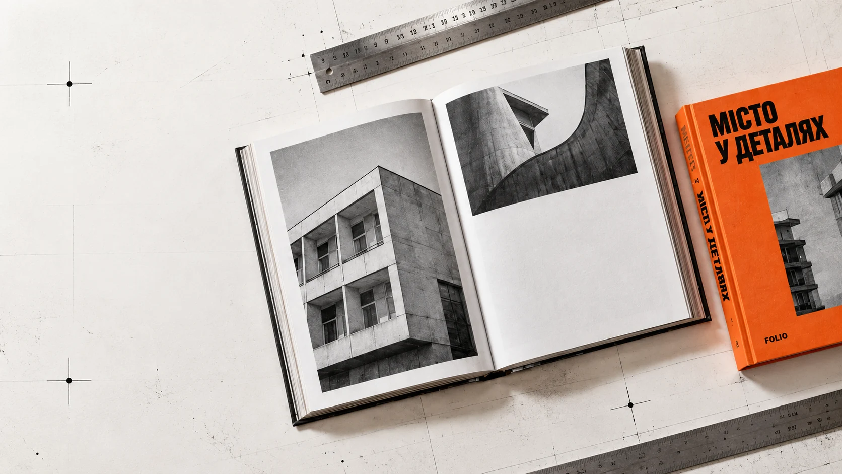 Розгорнутий фотозбірник і помаранчева книга на друкарському столі